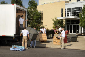 people loading truck with furniture