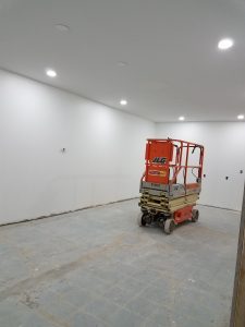 room with white walls & ceiling, genie elevator in center