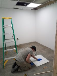 man cutting drop ceiling tile